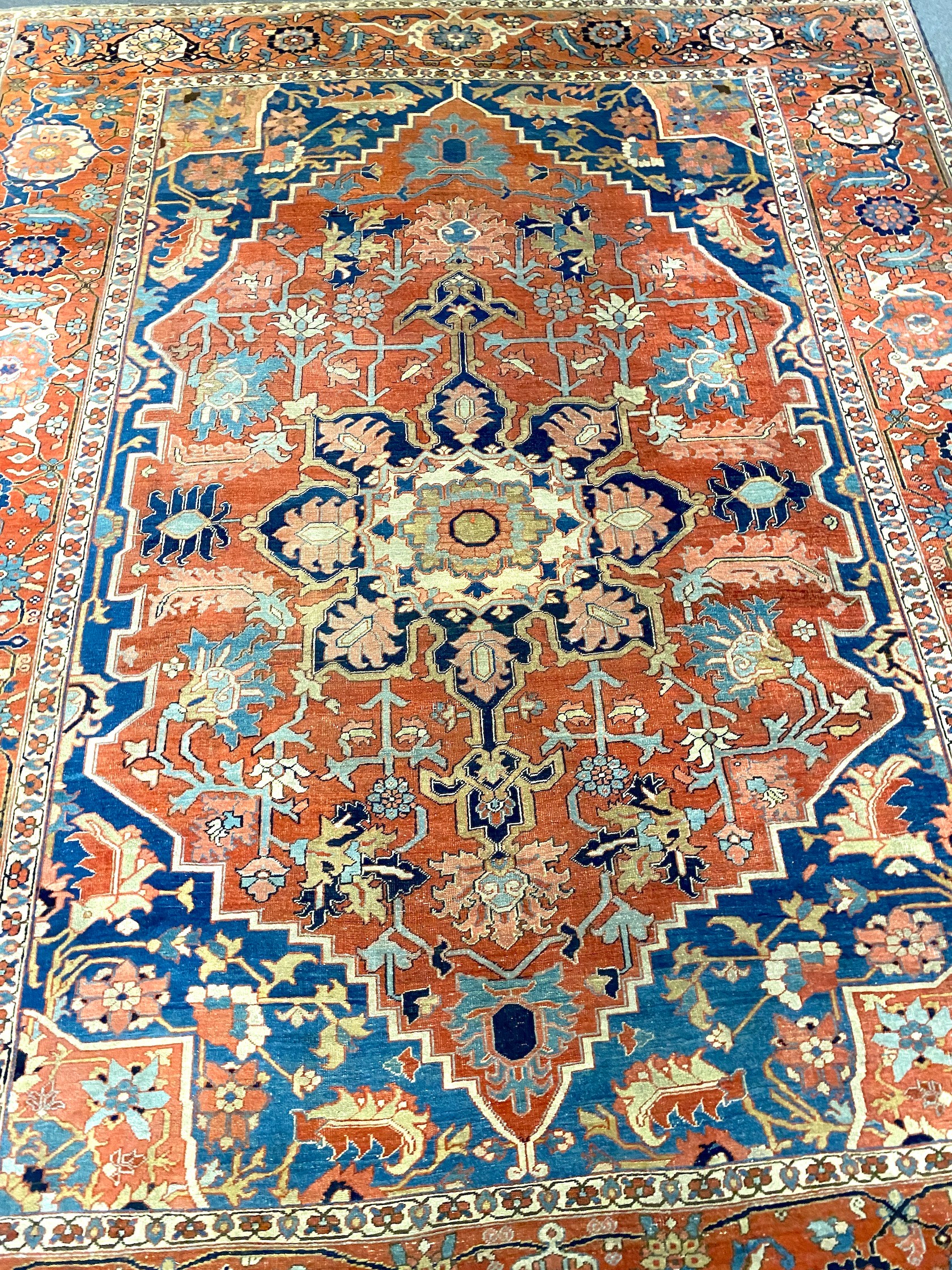 An antique Heriz brick red ground carpet, 370cm x 290cm